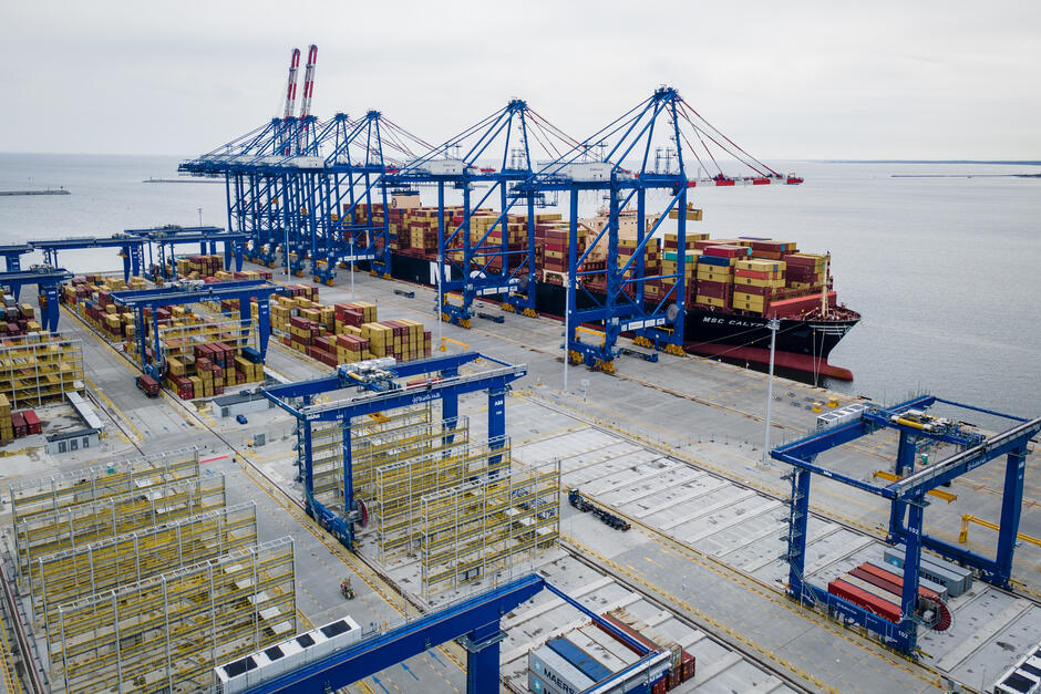 Zdjęcie przedstawia z lotu ptaka nowo otwarty terminal kontenerowy z zacumowanym statkiem MSC CALYPSO oraz imponującą infrastrukturą przeładunkową.