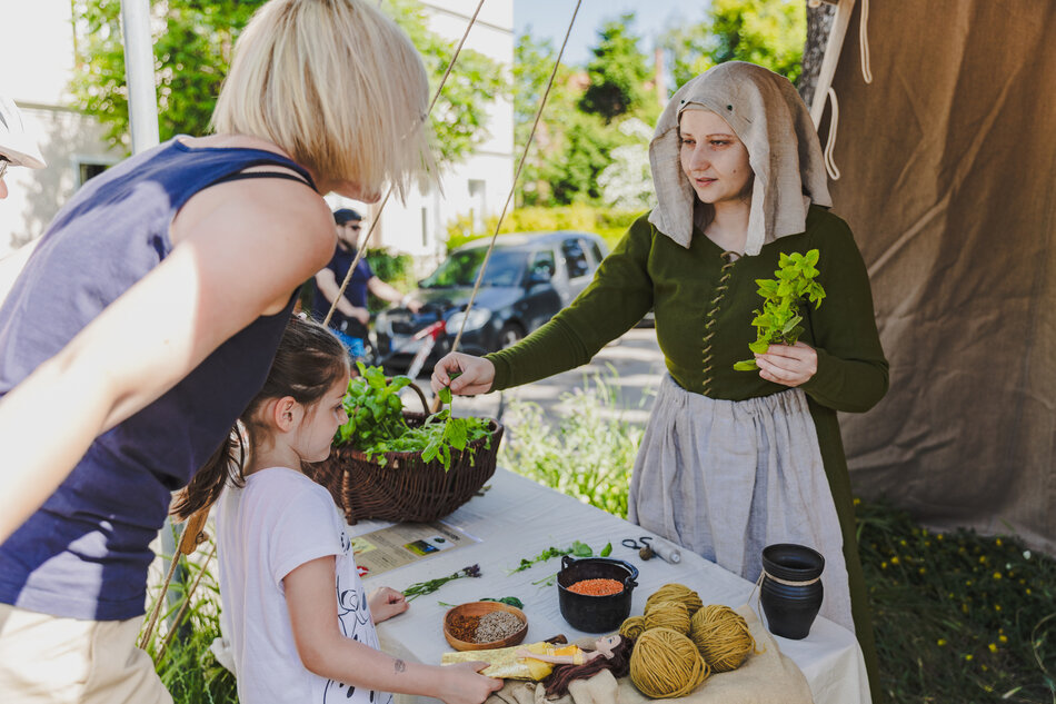 Trzy kobiety pozują do zdjęcia w historycznych strojach